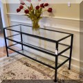 F41. Metal and glass tiered console table. 
